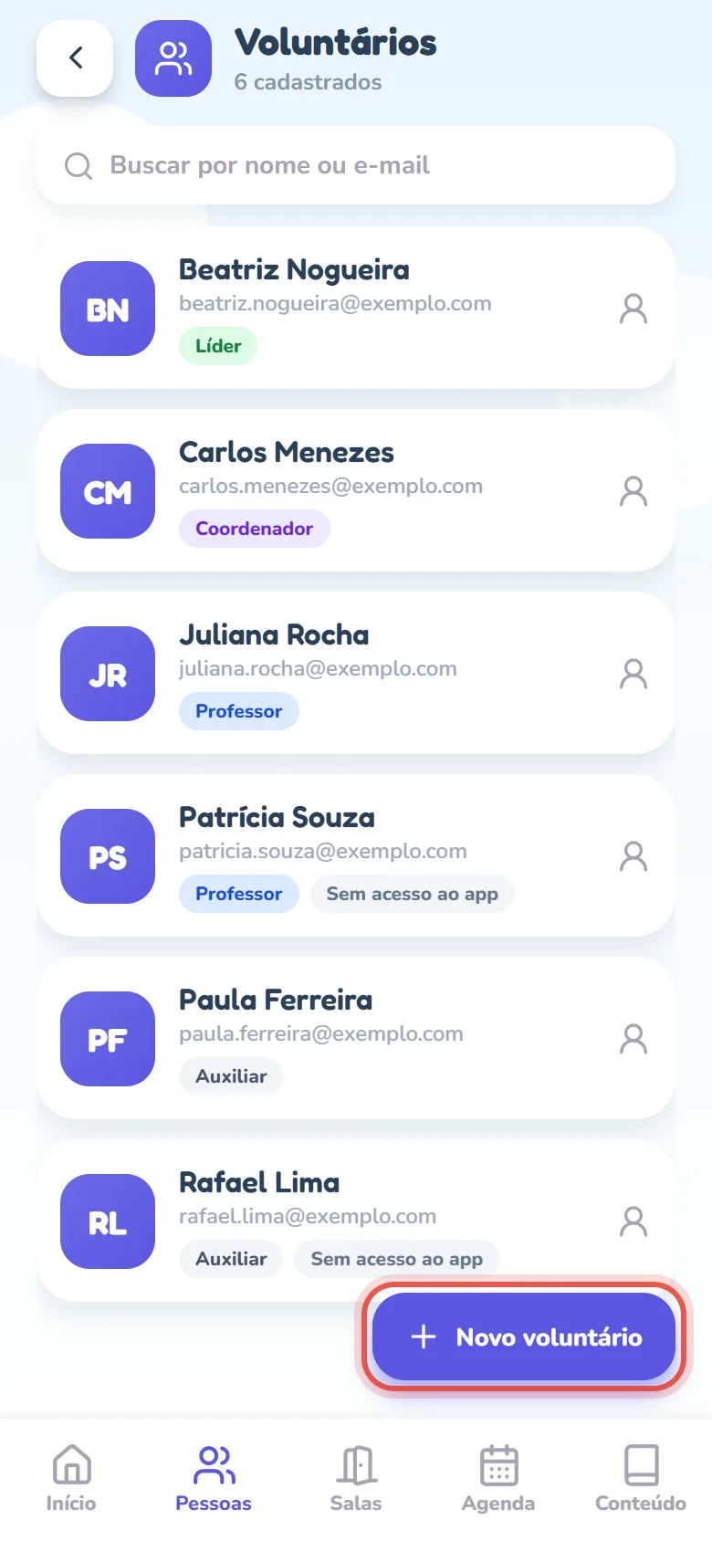Tela Voluntários com o subtítulo 6 cadastrados, o campo Buscar por nome ou e-mail e a lista da equipe em ordem alfabética — Beatriz Nogueira, Carlos Menezes, Juliana Rocha, Patrícia Souza, Paula Ferreira e Rafael Lima —, cada pessoa com as iniciais num quadrado roxo, o e-mail e a etiqueta colorida do cargo (Líder, Coordenador, Professor, Auxiliar); Patrícia Souza e Rafael Lima têm também o selo cinza Sem acesso ao app. No canto de baixo, o botão Novo voluntário, em destaque.